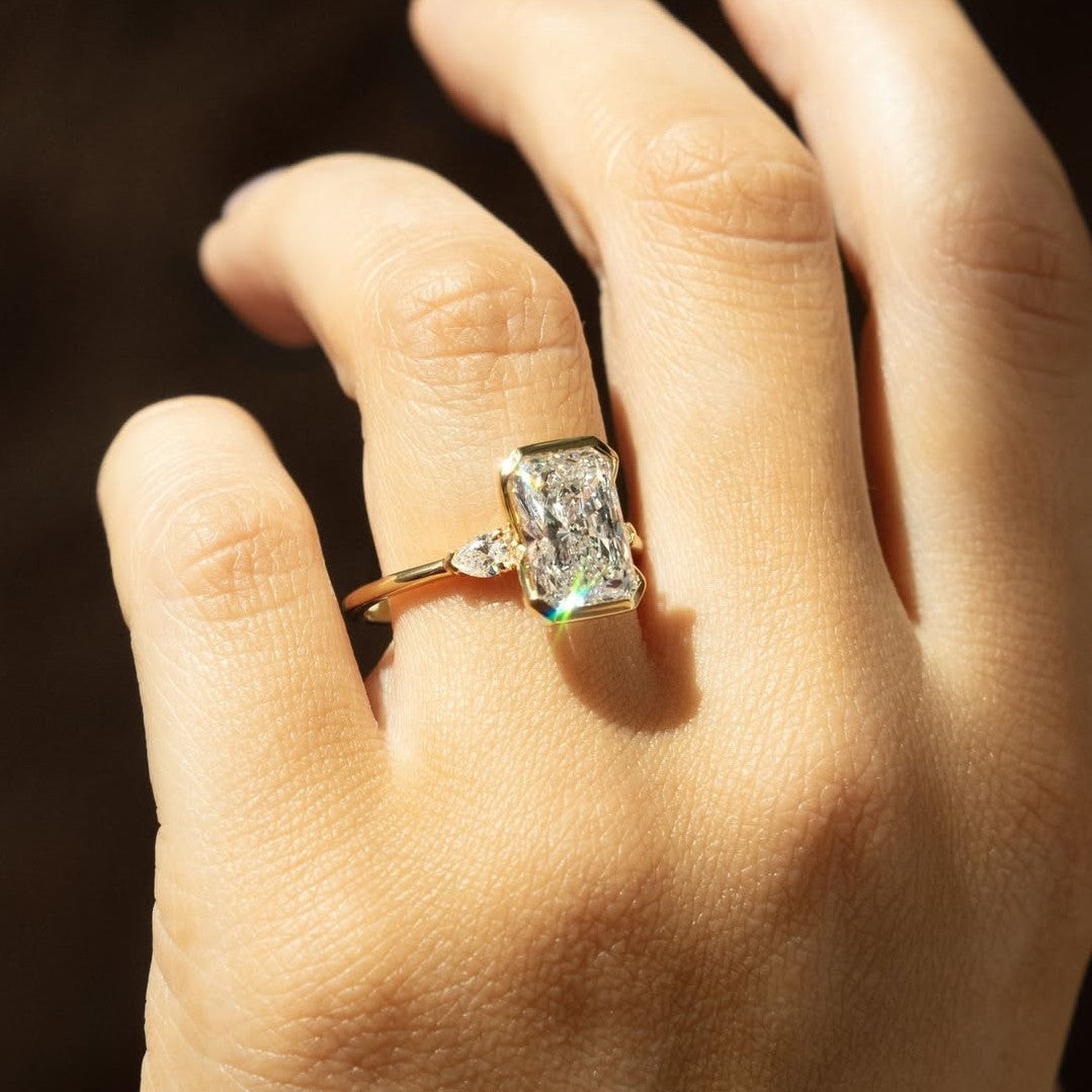 Radiant 3 Stone Engagement Ring with Pear Accent Half Bezel | Lab Grown Diamond | 14K Yellow Gold